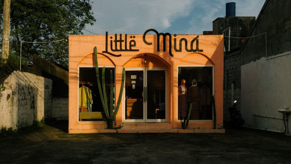 Charming vintage clothing shop with cactus decor under warm sunlight.